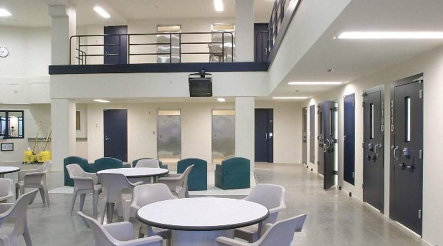 Correctional Dayroom Lighting featuring prison dayroom with tables and chairs